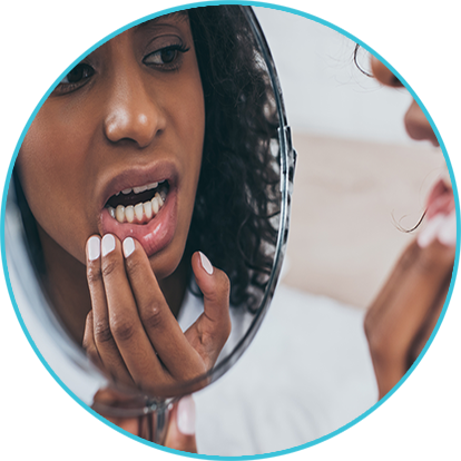 Women looking at her tooth in the mirror - Oral Surgery Services